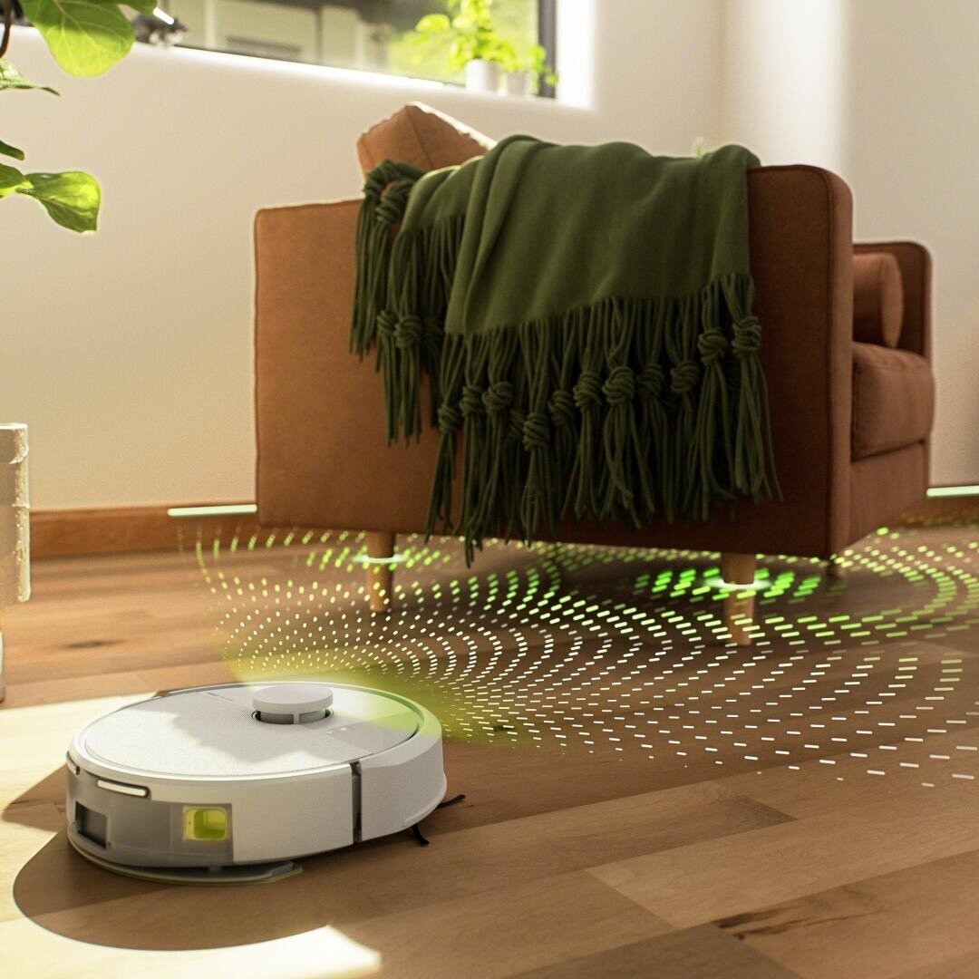 Ein Staubsaugerroboter arbeitet auf einem Holzboden neben einem braunen Sessel, der mit einer grünen Decke drapiert ist, wobei digitale Linien seine Sensornavigation veranschaulichen. Das Sonnenlicht fällt in den modernen, aufgeräumten Raum.