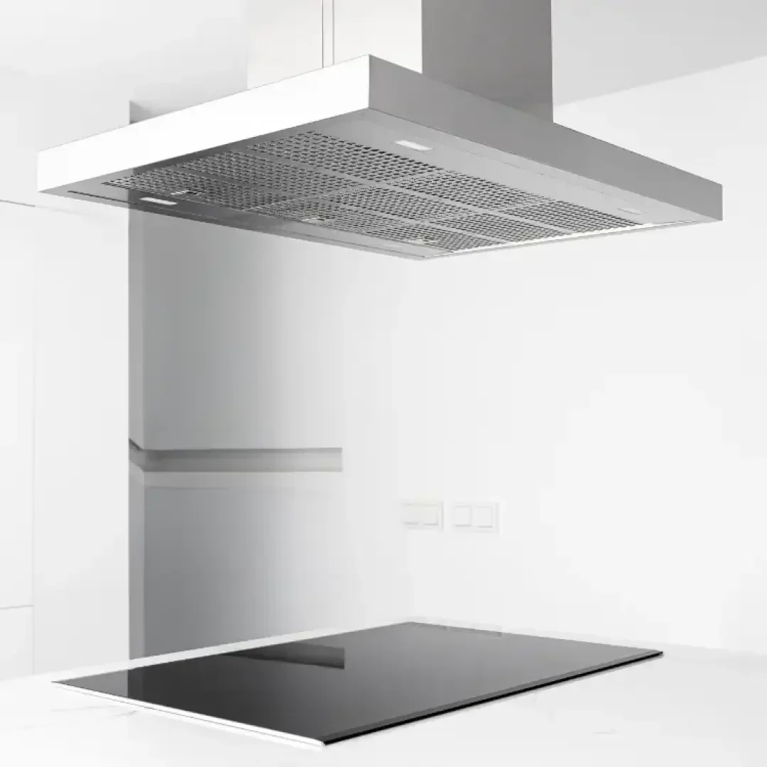 Eine moderne Dunstabzugshaube aus rostfreiem Stahl ist über einem eleganten Elektrokochfeld aus schwarzem Glas in einer minimalistischen weißen Küche angebracht. Der Hintergrund besteht aus weißen Wänden, Schränken und ein paar Steckdosen.