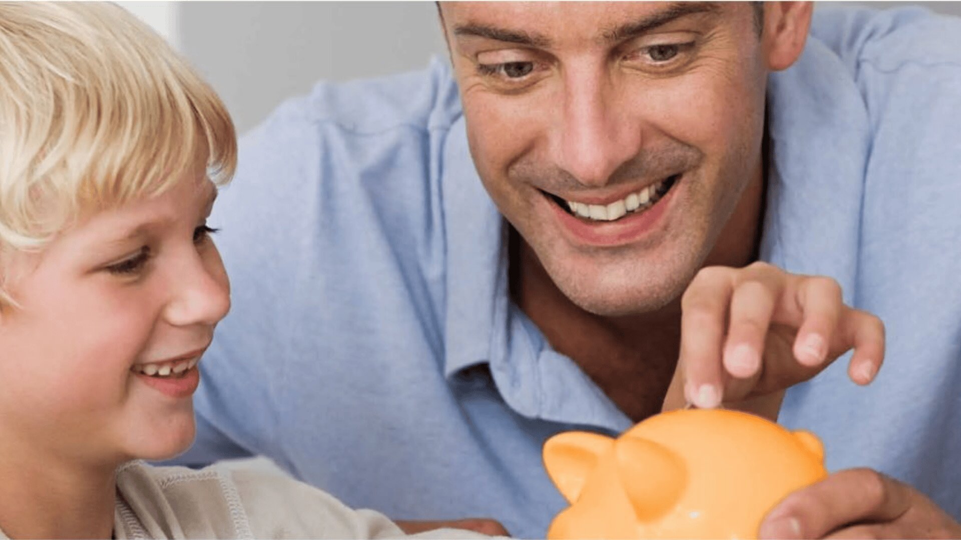 Ein lächelnder Erwachsener und ein Kind legen gemeinsam Münzen in ein orangefarbenes Sparschwein, was darauf hindeutet, dass sie Geld sparen oder etwas über Finanzen lernen.
