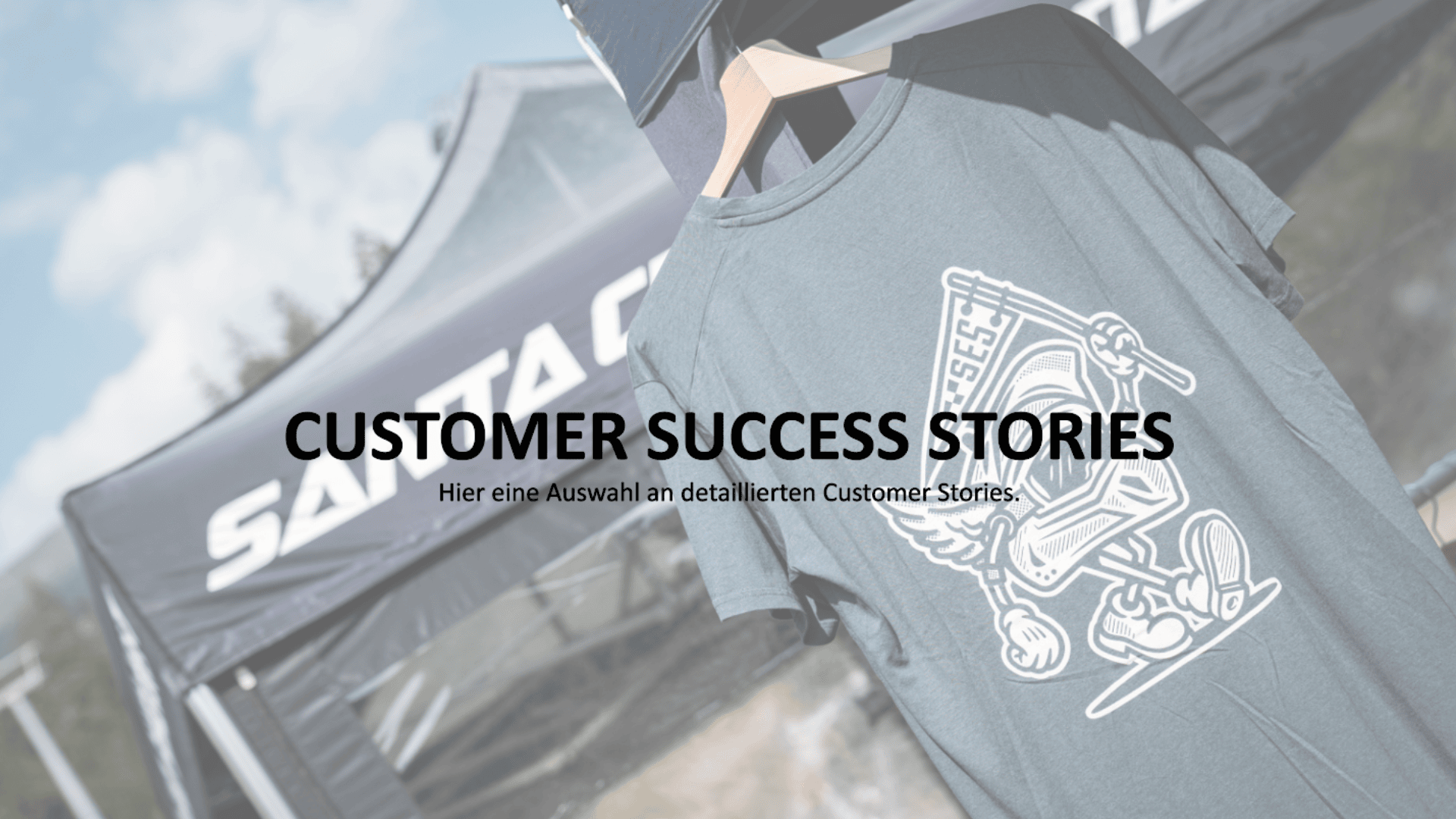 Ein graues T-Shirt mit einem grafischen Design hängt vor einem Outdoor-Zelt mit Markenzeichen. Der Text über dem Bild lautet: "Customer Success Stories". Hier eine Auswahl an detaillierten Kundengeschichten.